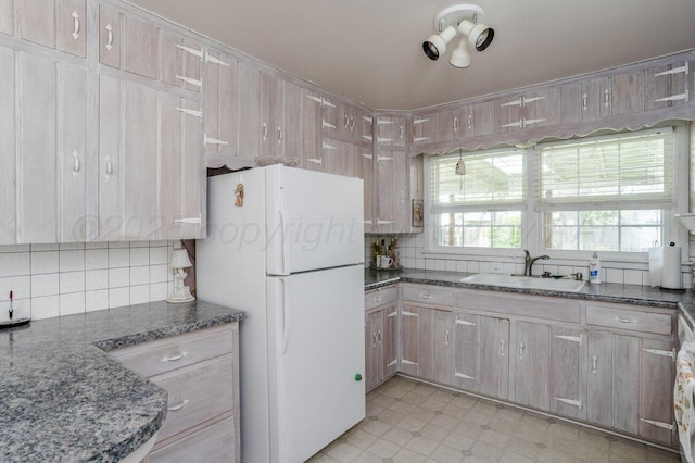 3406 Meadow Dr, Amarillo, TX 79109 - kitchen with freestanding refrigerator, decorative backsplash, dark stone counters, and light floors