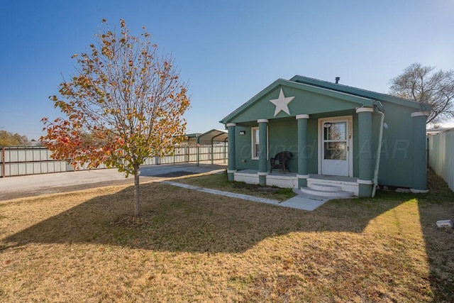 view of front of property with a front yard, fence, and stucco siding