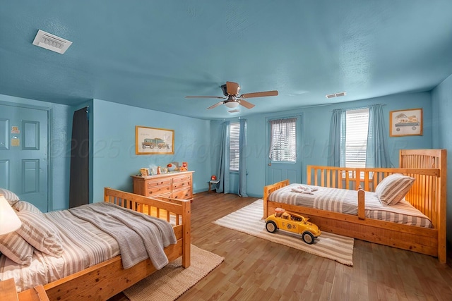 bedroom featuring ceiling fan, light wood-type flooring, and visible vents