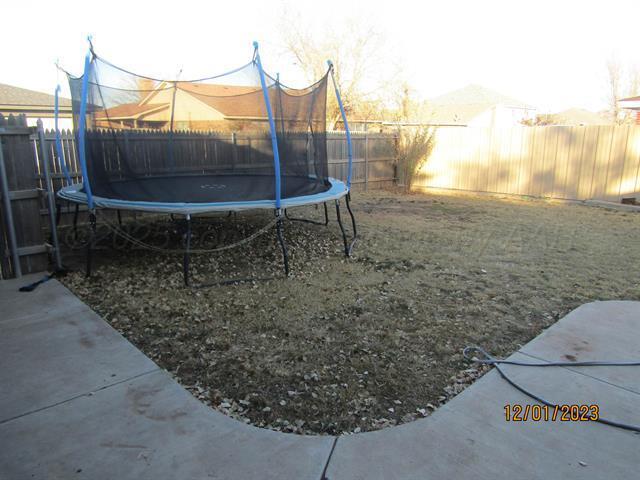 view of yard featuring a trampoline and a patio area