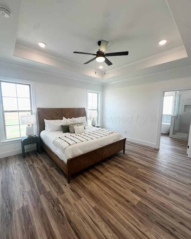 bedroom with dark wood-style flooring, ornamental molding, and a tray ceiling