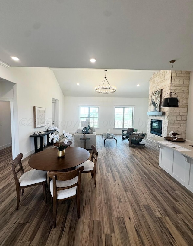 dining space with baseboards, a fireplace, dark wood-type flooring, and vaulted ceiling