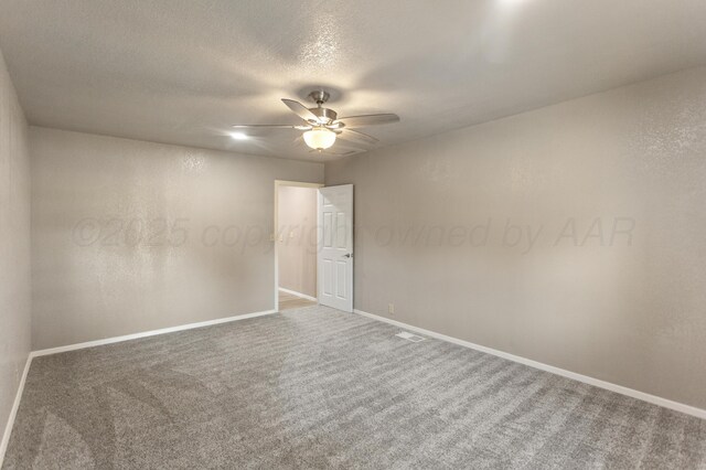 carpeted empty room with baseboards, ceiling fan, and a textured ceiling