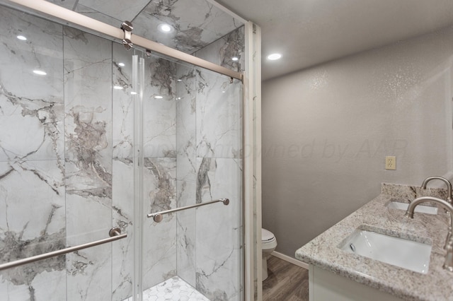 full bath with toilet, a sink, and a marble finish shower