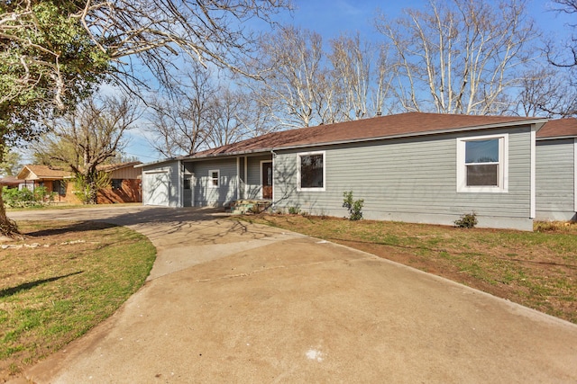 ranch-style home featuring a front yard, concrete driveway, and a garage