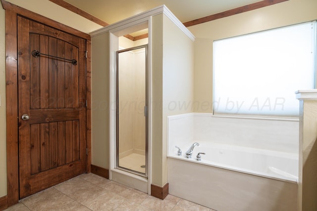 bathroom featuring tile patterned flooring, a shower stall, a garden tub, and baseboards