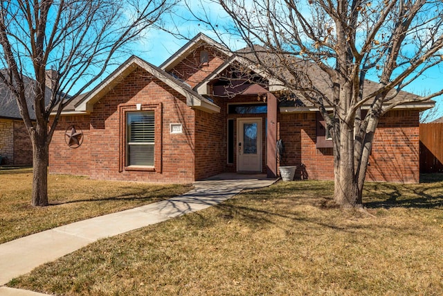 ranch-style house with brick siding, a front yard, and fence