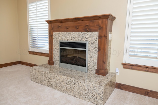 interior details featuring baseboards, carpet floors, and a fireplace