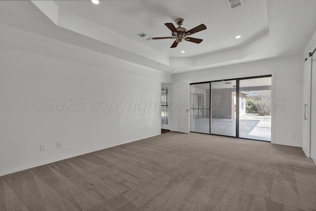 carpeted spare room featuring baseboards, visible vents, a raised ceiling, and recessed lighting