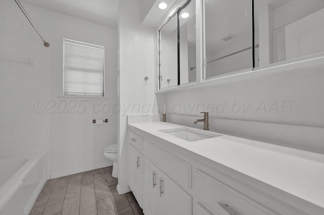 bathroom featuring wood finish floors, bathtub / shower combination, toilet, vanity, and baseboards