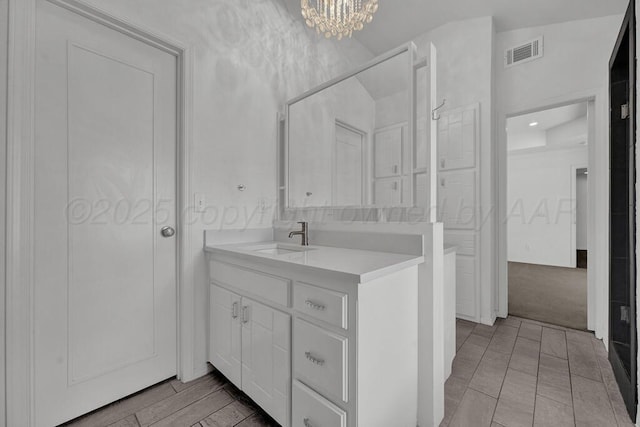 bathroom with vanity, visible vents, and a notable chandelier