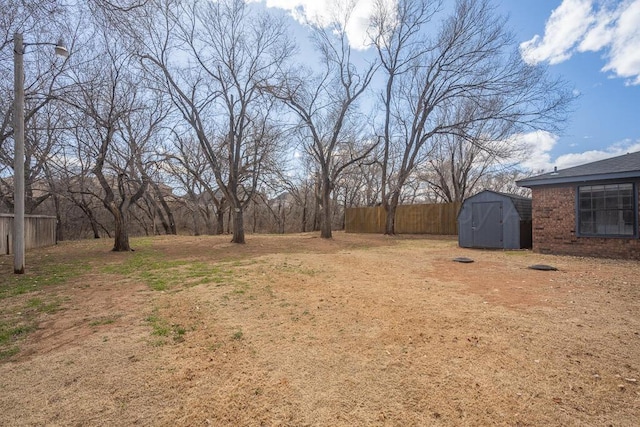 view of yard with fence, an outdoor structure, and a shed