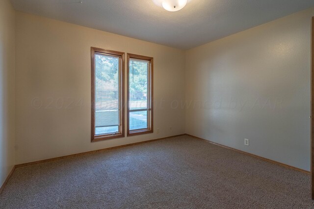 carpeted spare room with a textured ceiling