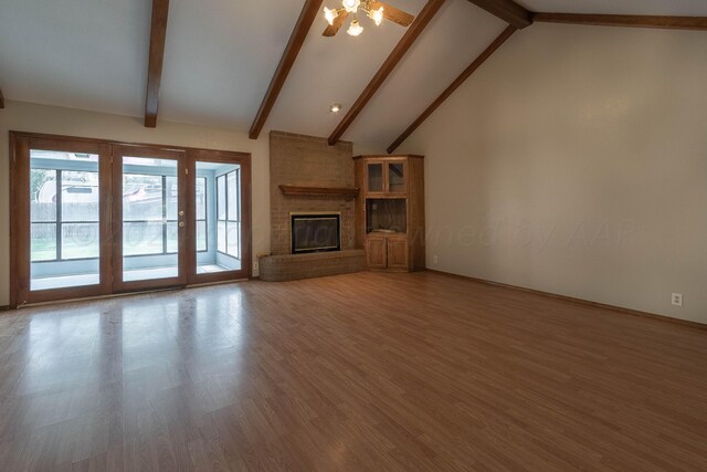 unfurnished living room featuring a brick fireplace, high vaulted ceiling, wood-type flooring, and beam ceiling