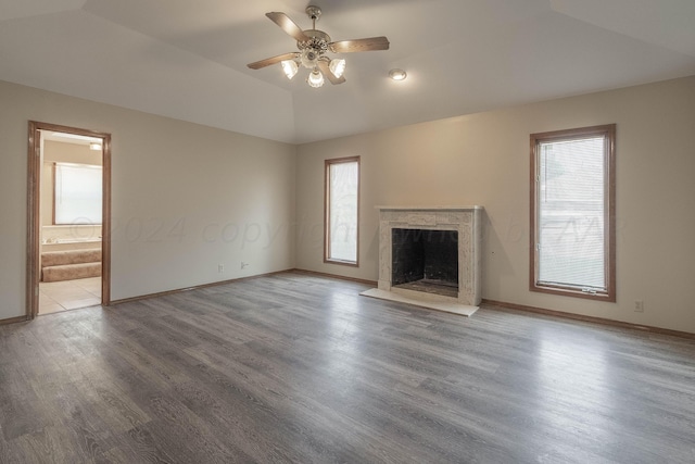 unfurnished living room featuring wood-type flooring, vaulted ceiling, and plenty of natural light