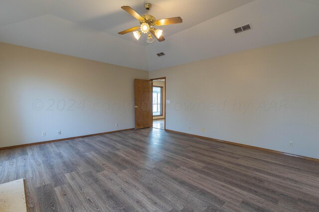 empty room with vaulted ceiling, ceiling fan, and dark hardwood / wood-style flooring