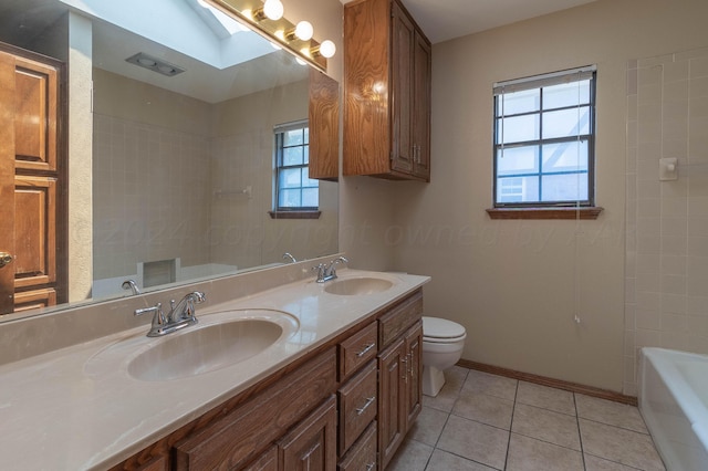 bathroom featuring toilet, tile patterned flooring, vanity, a skylight, and a bath