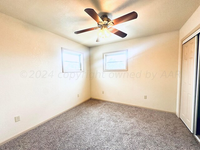 unfurnished bedroom featuring ceiling fan, a textured ceiling, and carpet flooring