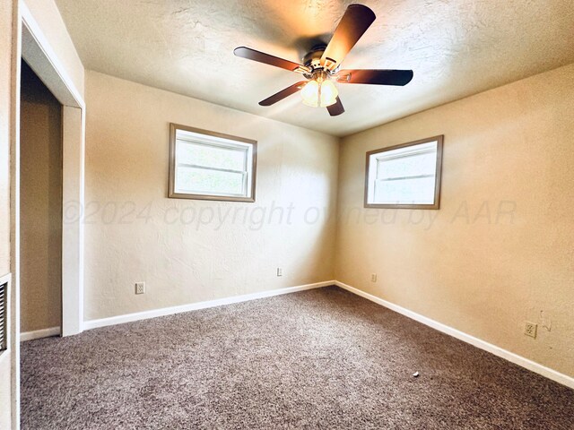 unfurnished bedroom featuring ceiling fan, multiple windows, and carpet flooring