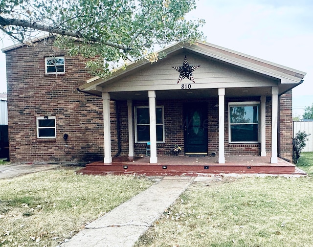 view of front of home with a porch and a front yard