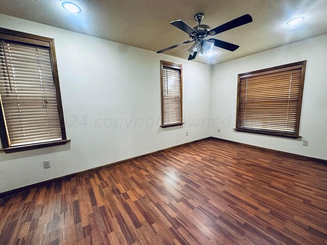 spare room featuring a textured ceiling, dark wood-type flooring, and ceiling fan