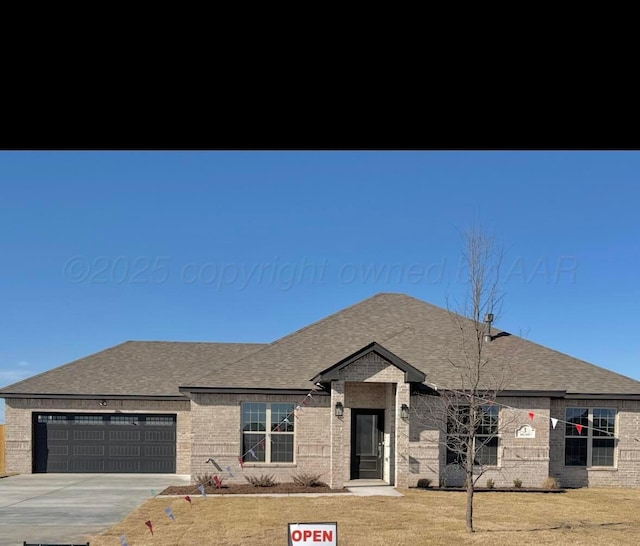 view of front facade with brick siding, driveway, a garage, and roof with shingles