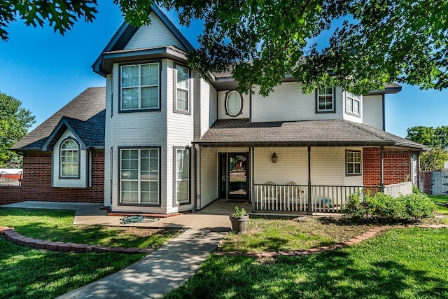 1204 University Pl, Borger, TX 79007 - view of front of house featuring a porch, a front yard, brick siding, and a shingled roof