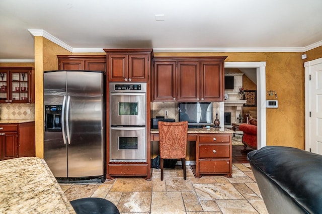 1204 University Pl, Borger, TX 79007 - kitchen featuring appliances with stainless steel finishes, decorative backsplash, ornamental molding, stone tile floors, and light stone counters