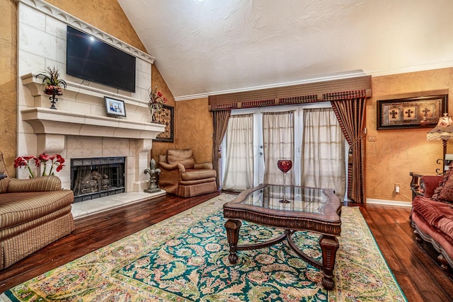 living room featuring dark wood-type flooring, a tiled fireplace, crown molding, and vaulted ceiling