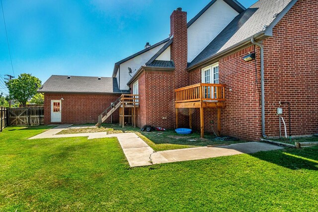 1204 University Pl, Borger, TX 79007 - rear view of house with a chimney, brick siding, stairs, and a wooden deck