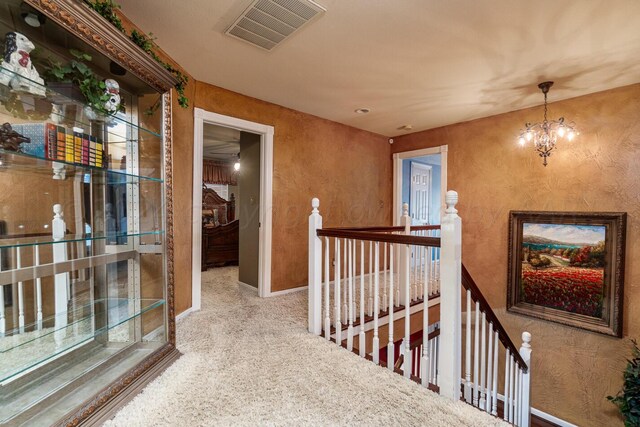 1204 University Pl, Borger, TX 79007 - hallway featuring an upstairs landing, a chandelier, baseboards, and carpet