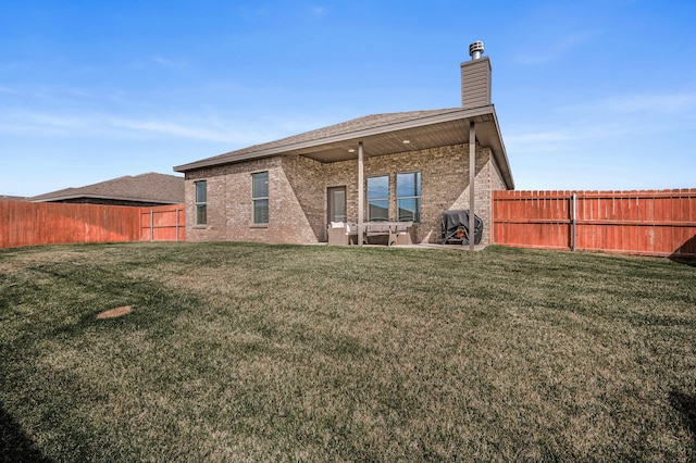 9209 Lexford Dr, Amarillo, TX 79119 - rear view of property featuring a fenced backyard, brick siding, a chimney, and a patio area