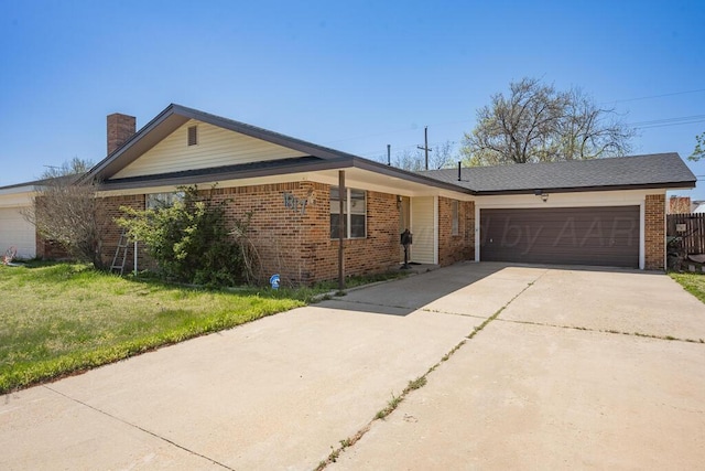 ranch-style house featuring an attached garage, a chimney, brick siding, and concrete driveway
