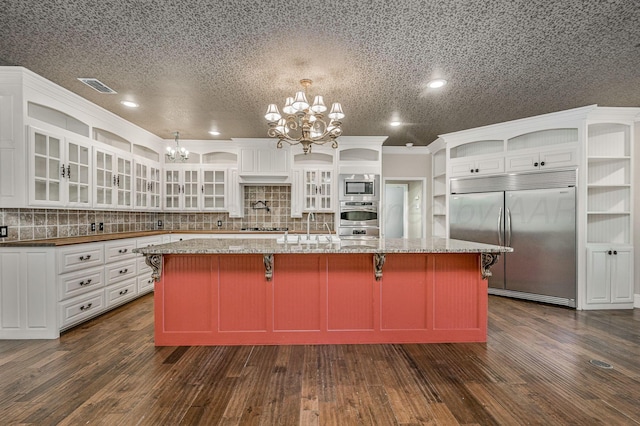 7723 Stuyvesant Ave, Amarillo, TX 79121 - kitchen with built in appliances, a chandelier, open shelves, backsplash, and white cabinetry