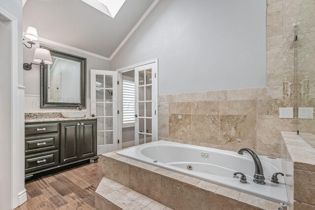 7723 Stuyvesant Ave, Amarillo, TX 79121 - bathroom with vaulted ceiling, a whirlpool tub, ornamental molding, vanity, and a skylight