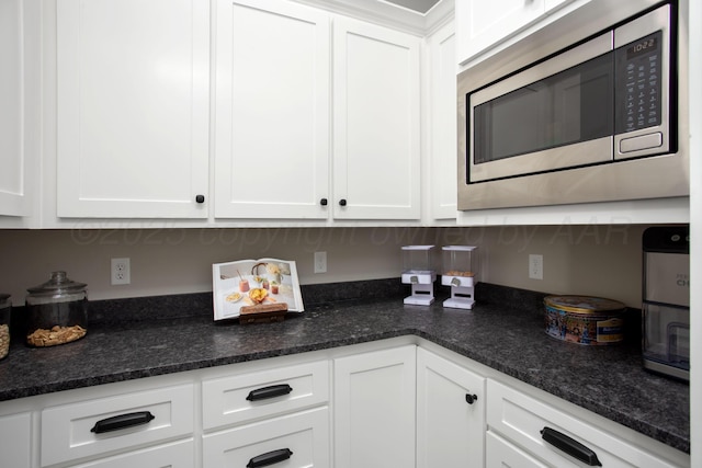 5609 Hollow Landing Ave, Amarillo, TX 79118 - kitchen with stainless steel microwave, white cabinetry, and dark stone counters