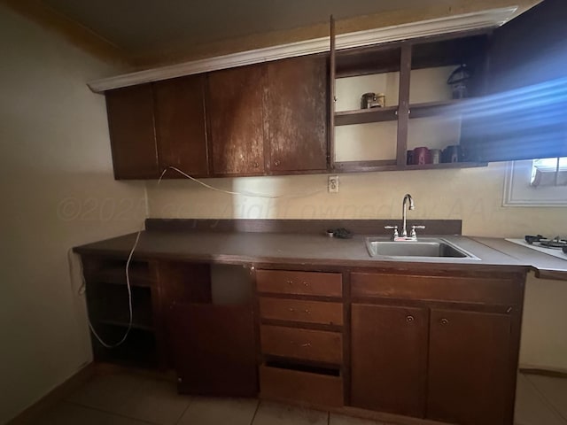 316 SE 21st Ave, Amarillo, TX 79109 - kitchen with a sink, light tile patterned floors, and dark brown cabinetry