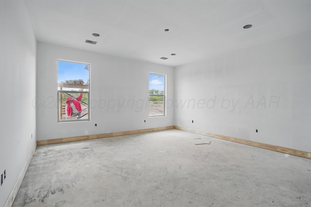 unfurnished room with concrete floors and baseboards