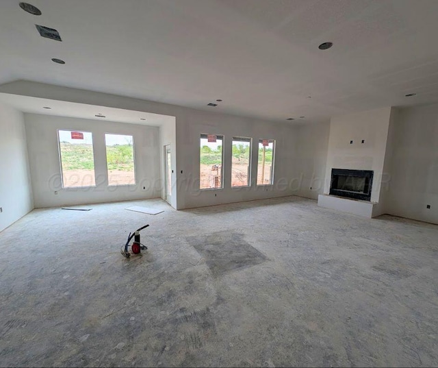 unfurnished living room with a fireplace with raised hearth