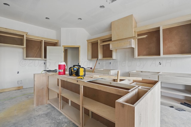 kitchen featuring concrete floors and vaulted ceiling