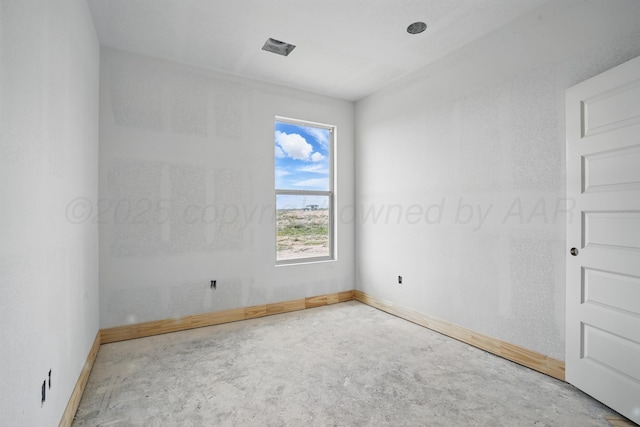 unfurnished room with concrete floors and baseboards