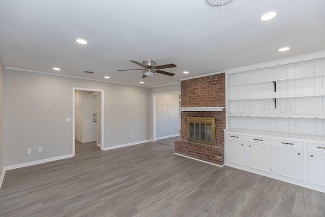 unfurnished living room with a fireplace, hardwood / wood-style flooring, ceiling fan, and crown molding