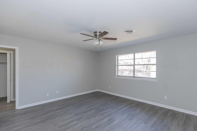 unfurnished room featuring dark wood-type flooring and ceiling fan