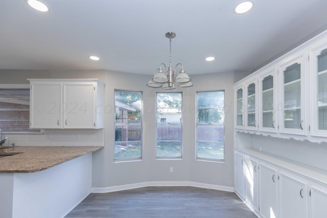 unfurnished dining area with dark hardwood / wood-style flooring, a notable chandelier, and sink