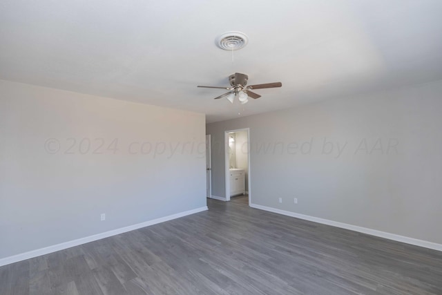 spare room with dark hardwood / wood-style flooring and ceiling fan