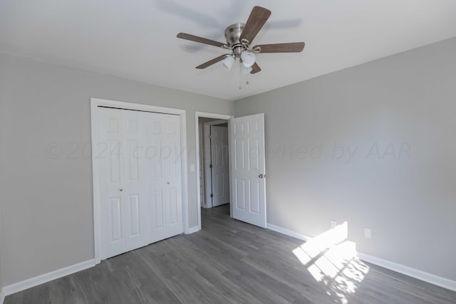 unfurnished bedroom featuring dark wood-type flooring, ceiling fan, and a closet