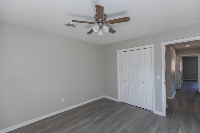 unfurnished bedroom featuring ceiling fan, dark hardwood / wood-style floors, and a closet