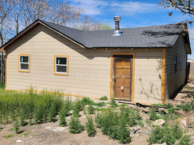 rear view of property featuring roof with shingles
