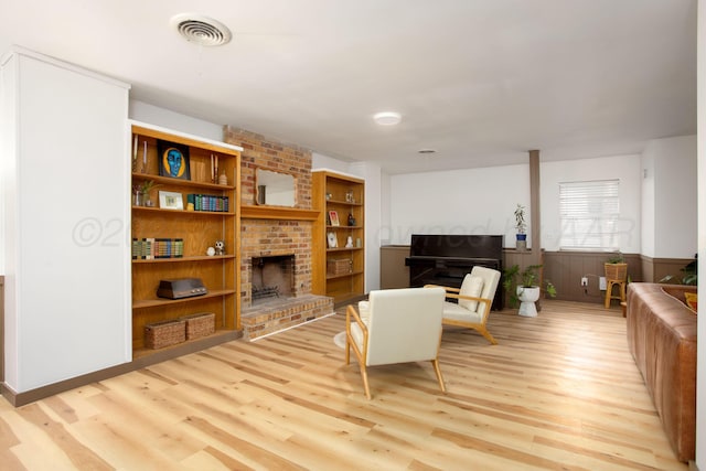 4818 SE 33rd Ave, Amarillo, TX 79103 - living room featuring a brick fireplace, light wood finished floors, and wainscoting