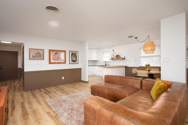 4818 SE 33rd Ave, Amarillo, TX 79103 - living room with light wood finished floors and a wainscoted wall